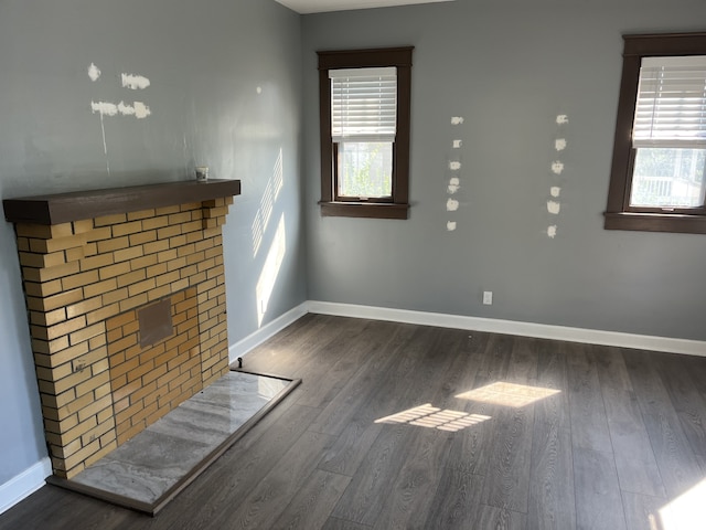 unfurnished living room with dark hardwood / wood-style floors and a healthy amount of sunlight