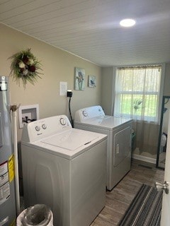 laundry area with wood-type flooring, water heater, and separate washer and dryer