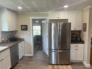 kitchen featuring appliances with stainless steel finishes, white cabinetry, and hardwood / wood-style floors