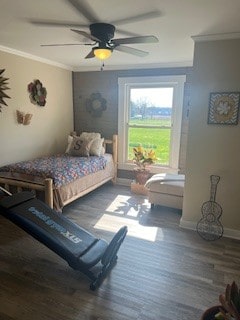 bedroom with ornamental molding, ceiling fan, and dark hardwood / wood-style flooring