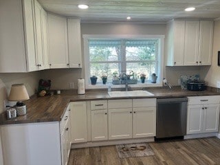 kitchen with dishwasher, sink, dark wood-type flooring, and white cabinetry