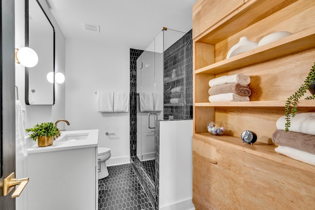 bathroom with tile patterned floors, vanity, toilet, and a shower with shower door