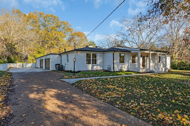 view of front facade with covered porch, central air condition unit, and a front yard