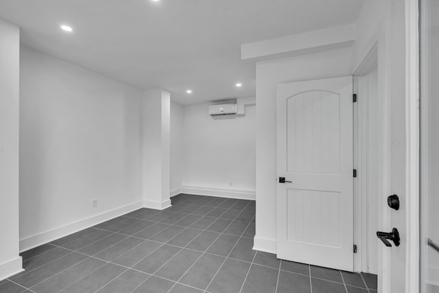 empty room with a wall mounted air conditioner and dark tile patterned floors