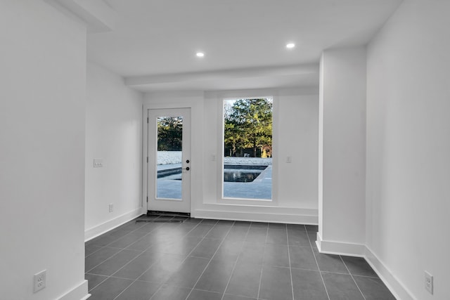 spare room featuring dark tile patterned flooring