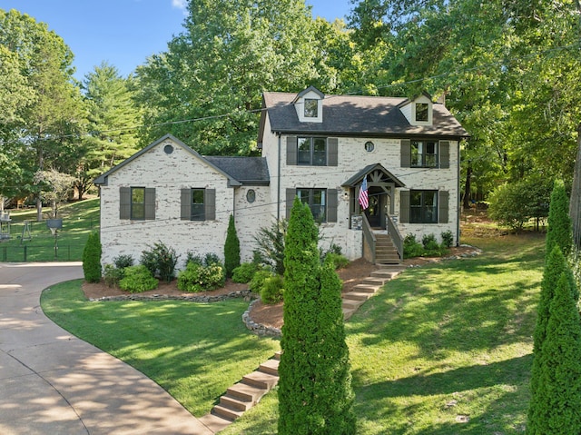 colonial inspired home with a front lawn