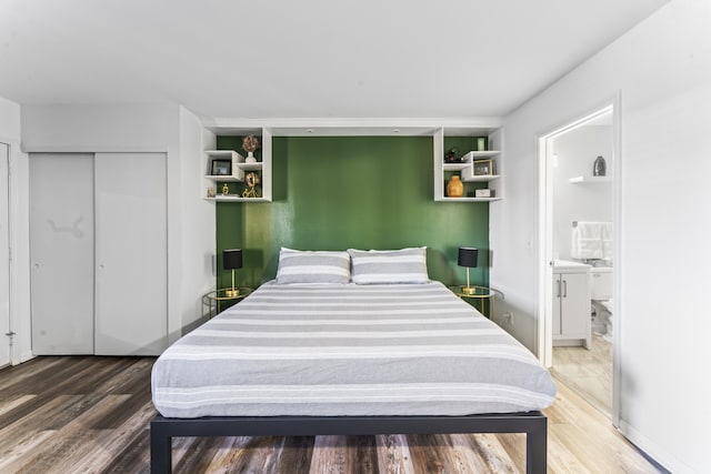 bedroom with wood-type flooring, ensuite bathroom, and a closet