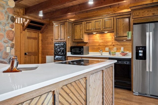 kitchen featuring light hardwood / wood-style floors, beamed ceiling, wooden ceiling, sink, and black appliances