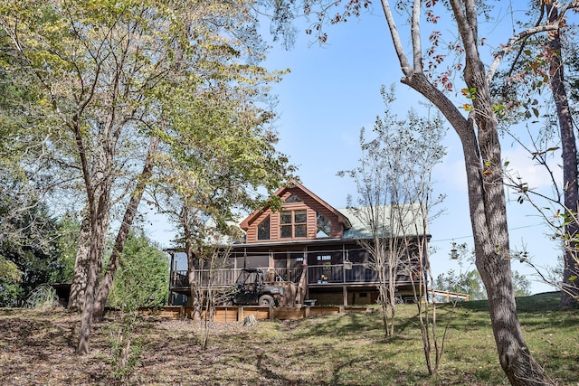 rear view of house featuring a deck and a lawn