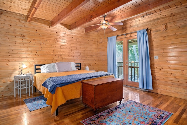 bedroom featuring ceiling fan, wood walls, wood-type flooring, and access to outside