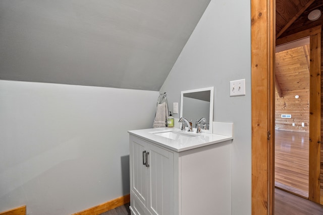 bathroom with vanity, lofted ceiling, and hardwood / wood-style floors