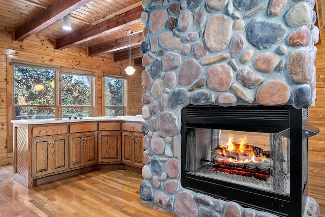 interior space featuring light wood-type flooring, wooden walls, a fireplace, and wooden ceiling