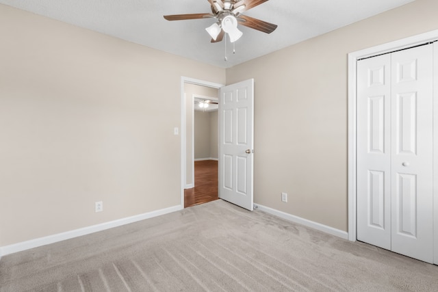 unfurnished bedroom with ceiling fan, light colored carpet, and a closet