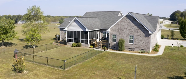 rear view of property with a lawn and a sunroom