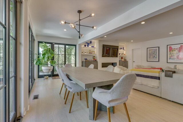 dining space featuring a notable chandelier and light wood-type flooring