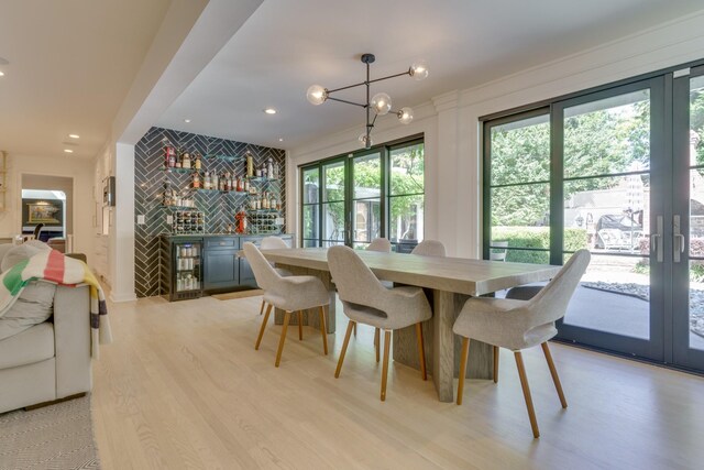 dining area with light hardwood / wood-style flooring and an inviting chandelier