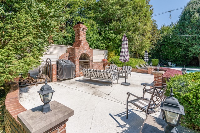 view of patio / terrace with an outdoor brick fireplace and area for grilling