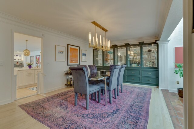 dining room featuring light hardwood / wood-style flooring, a chandelier, and ornamental molding