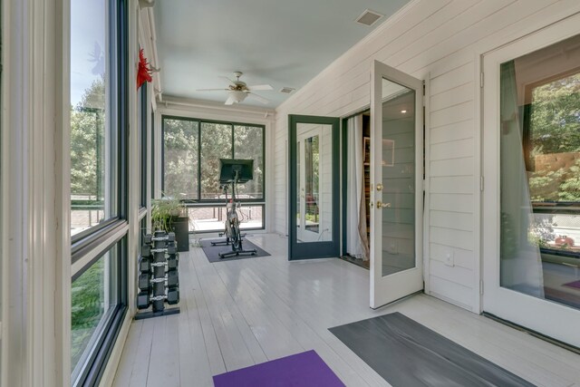 unfurnished sunroom featuring ceiling fan and french doors