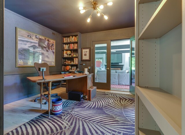 office space featuring a chandelier, built in shelves, hardwood / wood-style floors, ornamental molding, and french doors