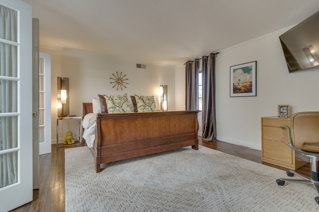 bedroom featuring ornamental molding and dark hardwood / wood-style flooring