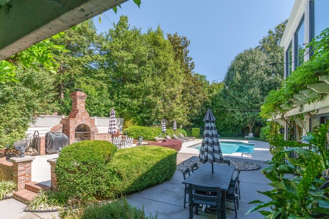 view of patio featuring area for grilling and an outdoor brick fireplace