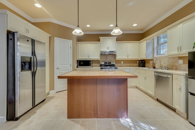 kitchen featuring a kitchen island, stainless steel appliances, tasteful backsplash, sink, and decorative light fixtures