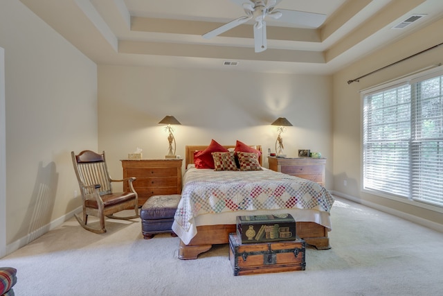 bedroom featuring ceiling fan, a raised ceiling, and carpet flooring