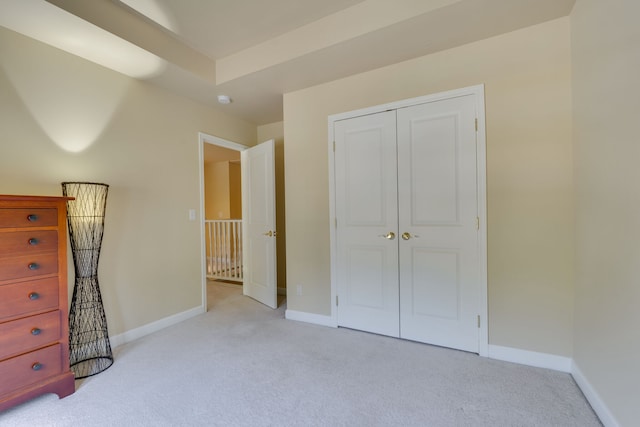 unfurnished bedroom with light carpet and a closet