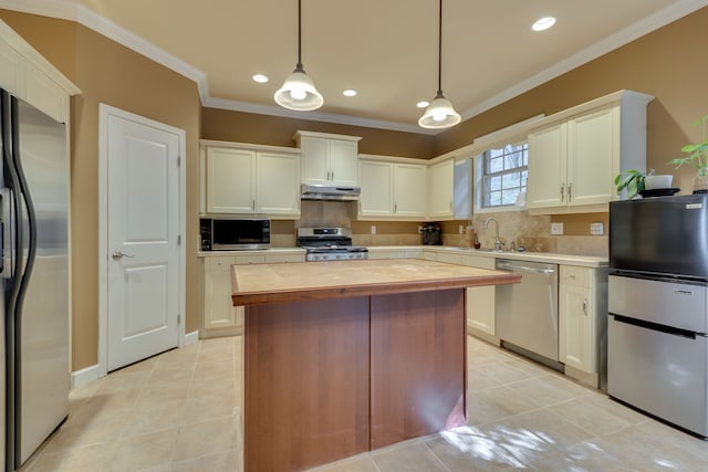 kitchen featuring appliances with stainless steel finishes, hanging light fixtures, light tile patterned floors, and backsplash