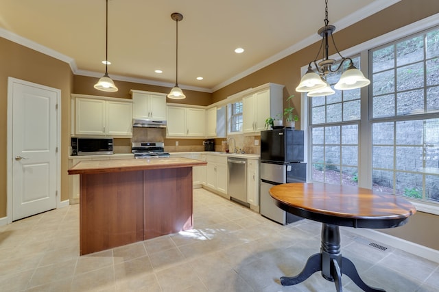 kitchen with stainless steel appliances, backsplash, white cabinets, and a wealth of natural light