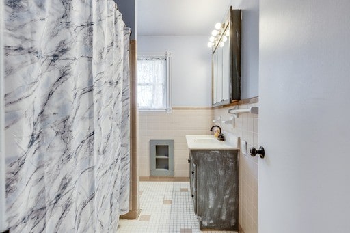 bathroom with tile walls, vanity, and a shower with shower curtain