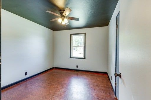 unfurnished room with ceiling fan and dark hardwood / wood-style flooring