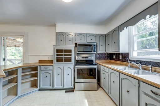 kitchen featuring gray cabinetry, stainless steel appliances, and a healthy amount of sunlight