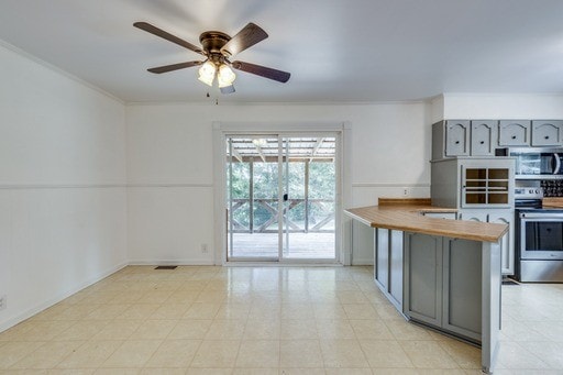 kitchen featuring kitchen peninsula, gray cabinetry, appliances with stainless steel finishes, ornamental molding, and ceiling fan