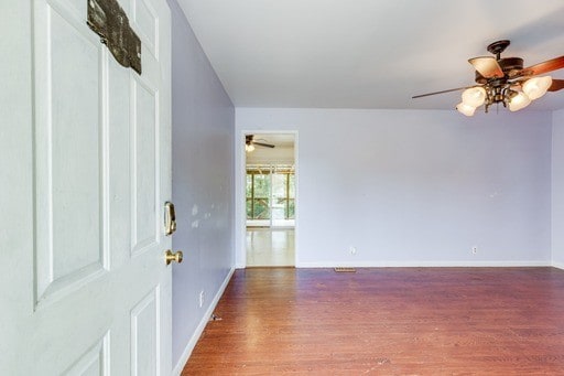 foyer entrance with ceiling fan and dark wood-type flooring