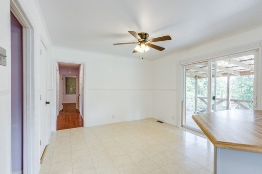 spare room with ornamental molding and ceiling fan