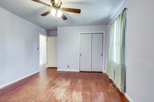 unfurnished bedroom featuring hardwood / wood-style floors, ceiling fan, and a closet