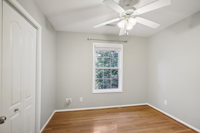 empty room with ceiling fan and light hardwood / wood-style flooring