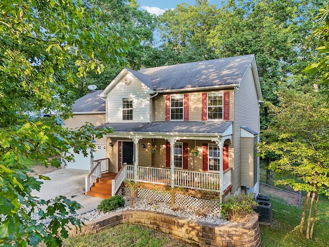 view of front of property with a garage, central air condition unit, and a porch