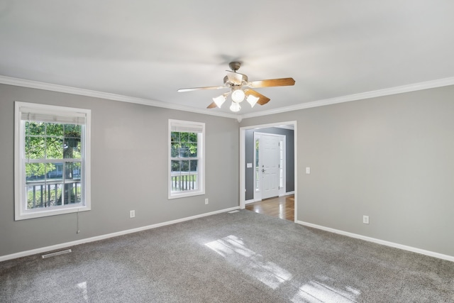 carpeted spare room with ornamental molding and a wealth of natural light