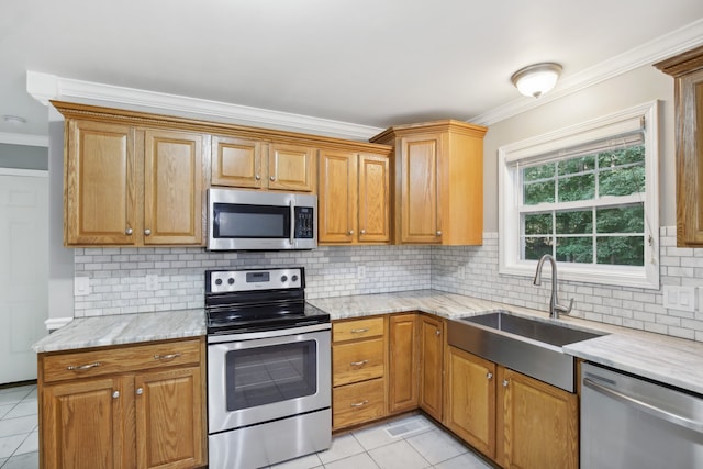 kitchen featuring sink, light tile patterned floors, appliances with stainless steel finishes, ornamental molding, and light stone countertops