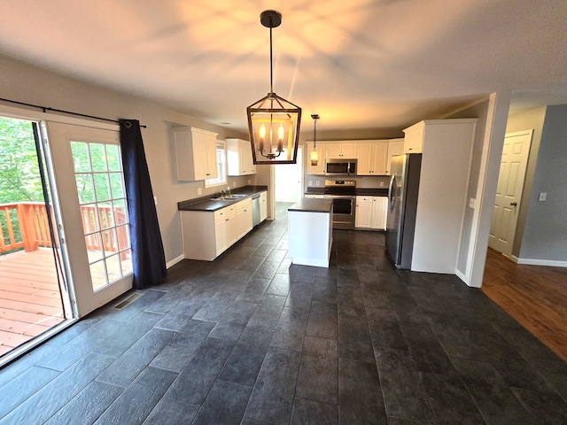 kitchen featuring sink, white cabinetry, hanging light fixtures, stainless steel appliances, and dark hardwood / wood-style flooring