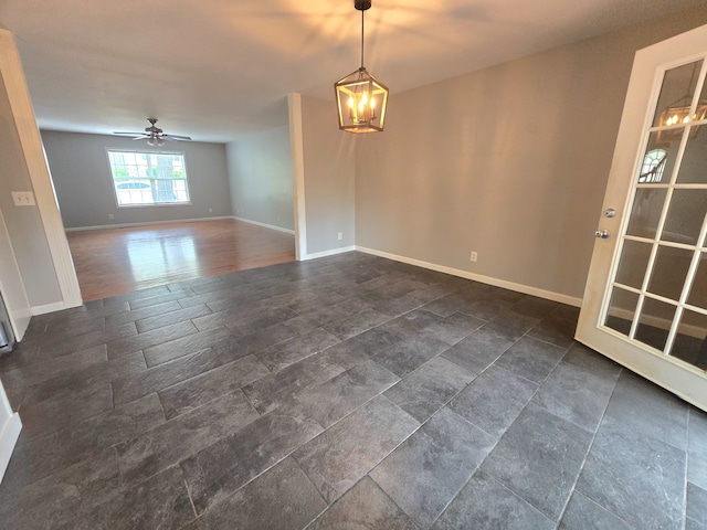 unfurnished room with ceiling fan with notable chandelier and dark hardwood / wood-style floors