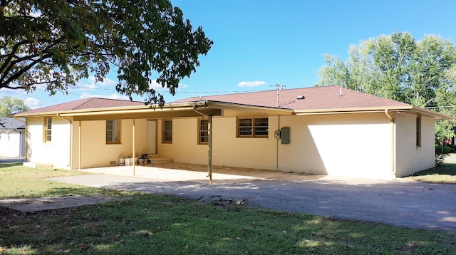 rear view of property featuring a patio and a yard