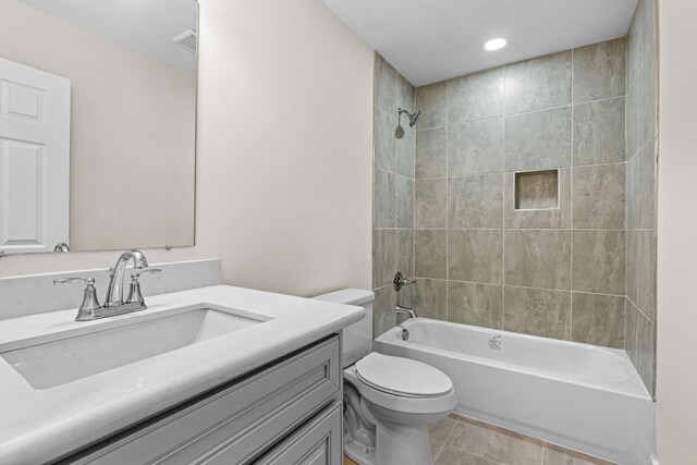 full bathroom with toilet, tiled shower / bath, vanity, and tile patterned flooring