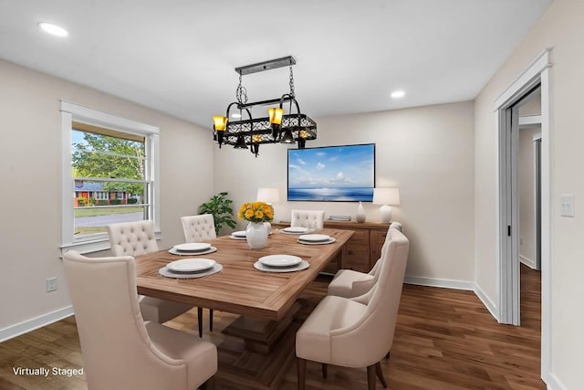 dining space with dark hardwood / wood-style flooring and a chandelier