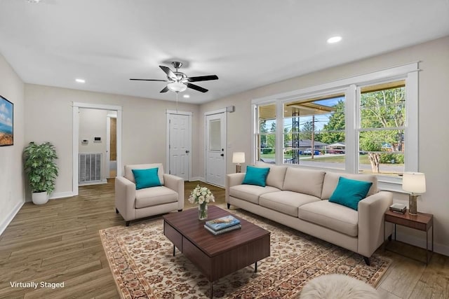 living room featuring hardwood / wood-style floors and ceiling fan