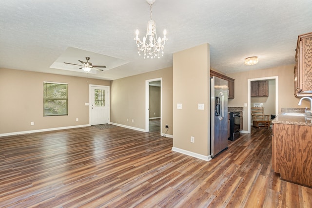 interior space featuring dark wood-type flooring, stainless steel refrigerator with ice dispenser, black range with electric stovetop, a textured ceiling, and ceiling fan with notable chandelier