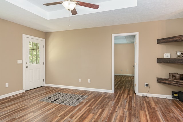 interior space with a skylight, ceiling fan, a textured ceiling, and dark hardwood / wood-style flooring